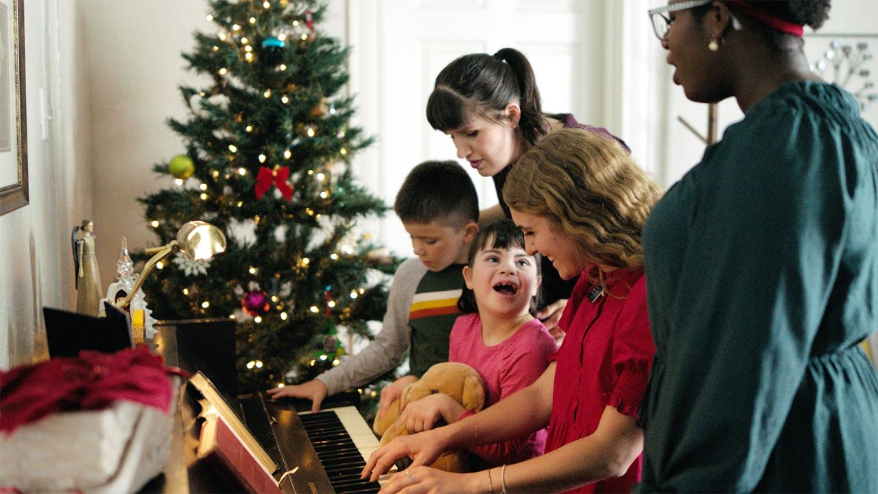 Deux missionnaires jouent du piano avec une famille