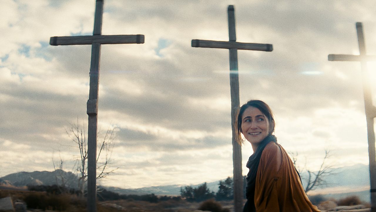 La femme marche devant trois croix