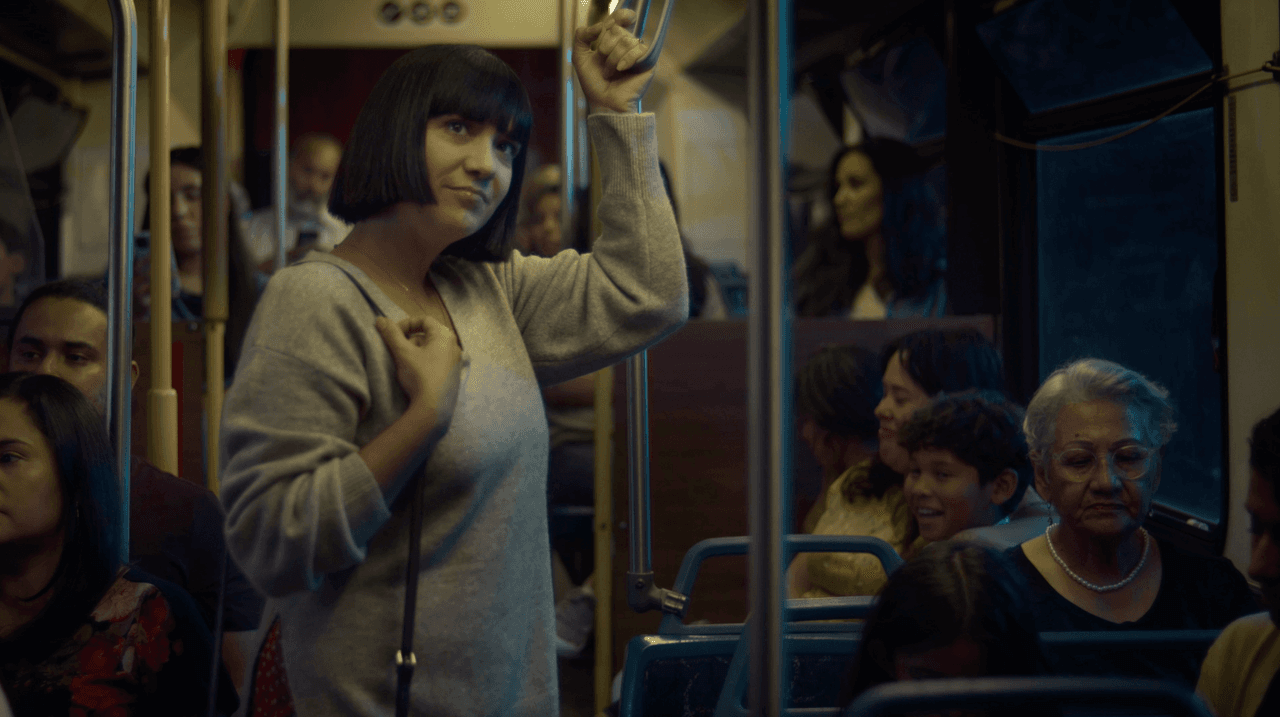 Une femme sourit légèrement alors qu'elle monte dans une rame de métro
